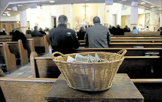  ?? Lake Fong/Post-Gazette ?? A collection basket is pictured at St. Mary of Mercy Parish, Downtown.