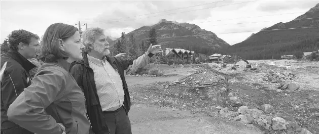  ?? THE CANADIAN PRESS ?? Premier Alison Redford looks over Canmore’s Cougar Creek area Monday with Canmore Mayor John Borrowman, right, and Minister Doug Griffiths at left.