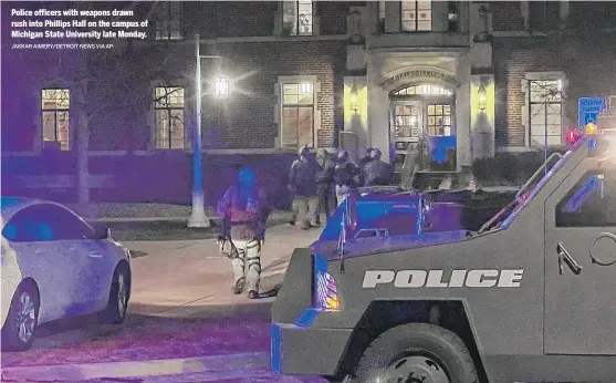  ?? JAKKAR AIMERY/DETROIT NEWS VIA AP ?? Police officers with weapons drawn rush into Phillips Hall on the campus of Michigan State University late Monday.