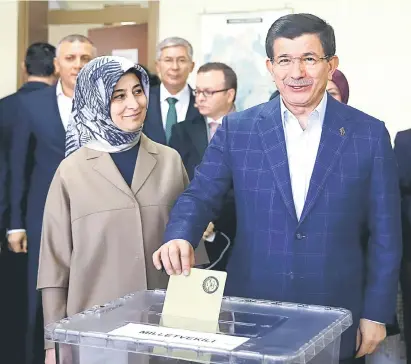  ?? — Gambar Reuters ?? KEDUDUKAN GENTING: Davutoglu membuang undi sambil diperhatik­an isterinya Sare di sebuah pusat pengundian semasa pilihan raya parlimen di Konya, semalam.