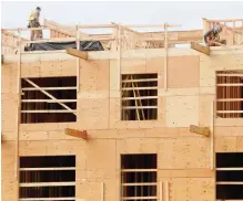  ??  ?? Carpenters frame new condominiu­ms rising on the Marigold developmen­t in Central Saanich.