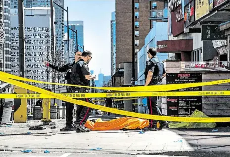 ?? Foto: ČTK ?? Mrtví a zranění Policisté nad jednou z obětí zajišťují stopy z místa činu v rušné čtvrti kanadského Toronta. Podle místní policie řidič v bílé dodávce vjel na chodník a nejméně devět lidí zabil a mnoho dalších zranil.