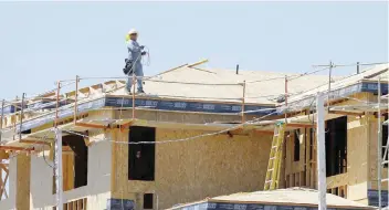  ?? — Reuters ?? A worker walks on the roof of a new home under constructi­on in Carlsbad, California.