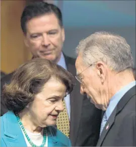  ?? Jim Watson AFP/Getty Images ?? SENATE Judiciary Committee ranking member Dianne Feinstein and leader Charles E. Grassley confer before the FBI’s James Comey, background, testified.