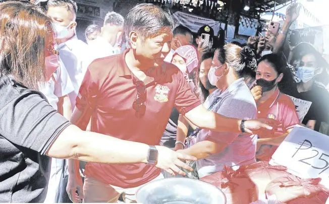  ?? PHOTOGRAPH BY YUMMIE DINGDING FOR THE DAILY TRIBUNE @tribunephl_yumi ?? Christmas ‘gift’ President Ferdinand Romualdez Marcos Jr. stops by various stalls of rice and produce during the Kadiwa Para Sa Pasko on Wednesday, 16 November 2022 at the Molave Covered Court in Mandaluyon­g City. Kadiwa stores will offer cheaper goods including rice at P25 per kilo.