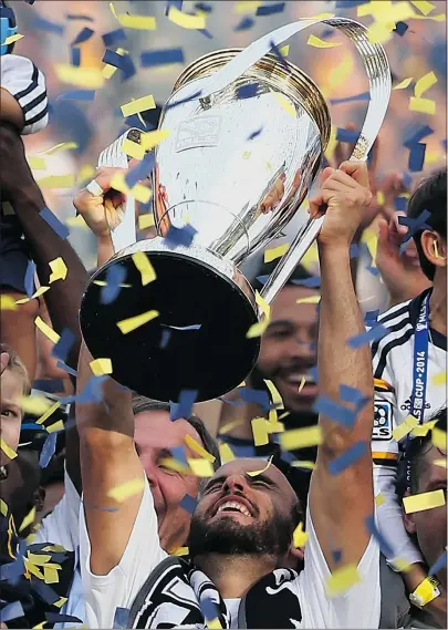  ?? — GETTY IMAGES ?? Los Angeles Galaxy forward Landon Donovan hoists the Philip F. Anschutz Trophy after beating the New England Revolution 2-1 in the 2014 MLS Cup on Sunday in Carson, Calif.