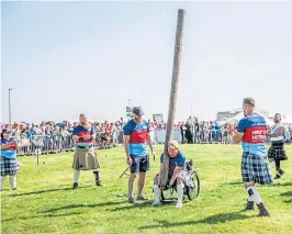  ??  ?? COMPETITOR: David Dent tosses the caber with the Help for Heroes team alongside James Holburn, right