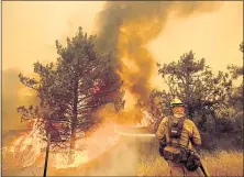  ??  ?? A firefighte­r scrambles to stop the Pawnee fire as it spots across Highway 20 near Clearlake Oaks.