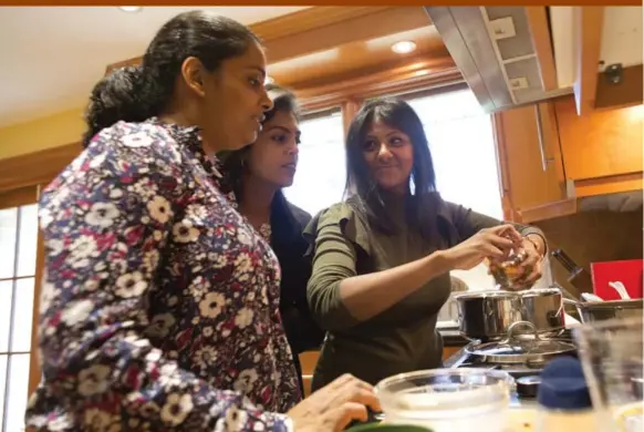  ?? LUCAS OLENIUK PHOTOS/TORONTO STAR ?? Vani Gunabalasu­bramaniam, left, Sukaneya Moorthy, middle, and Kasthurie Sugumar gather around the stove to taste their prawn curry, made from a recipe in Handmade.