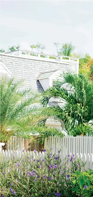  ??  ?? RIGHT White clapboard, picket fences and palm trees make this a chic, simple Caribbean home for Wiggy and her family. Scarlett and Marina peek through old-fashioned shutters that can be ‘battened down’ should a tropical storm blow in