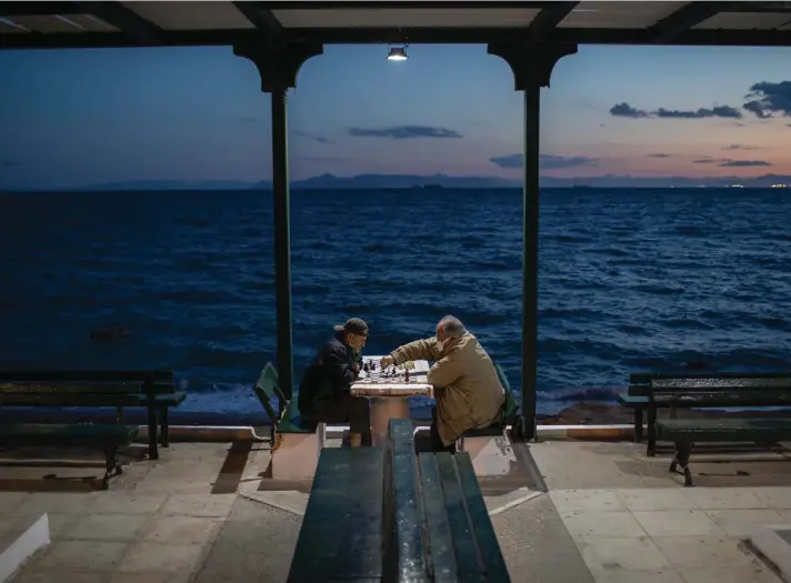  ??  ?? Two men wearing protective face masks play chess in Alimos, a seaside suburb of Athens, on Tuesday. Photo: AP