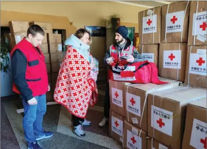  ?? RED CROSS SOCIETY OF CHINA ?? A Red Cross worker distribute­s China’s first shipment of humanitari­an assistance to Ukraine, which arrived in the western Ukrainian city of Chernivtsi on March 12.