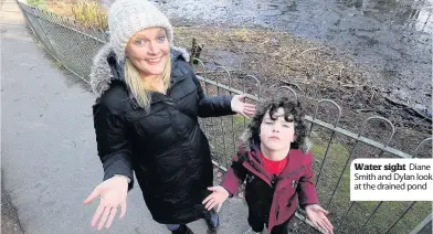  ??  ?? Water sight Diane Smith and Dylan look at the drained pond