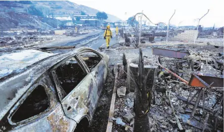  ?? Gregory Bull / Associated Press ?? Fire crews search for hot spots among destroyed homes in the Rancho Monserate Country Club community in Fallbrook in northern San Diego County. The Lilac Fire has destroyed at least 85 structures and killed 25 horses at a training facility.