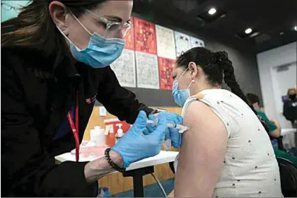  ?? ANNE WERNIKOFF / CAL MATTERS ?? An East Palo Alto resident is inoculated during a COVID-19 vaccinatio­n clinic run by Ravenswood Family Health Network at Facebook headquarte­rs in Menlo Park on April 10. Ravenswood clinics serve low-income population­s with more than half of their patients participat­ing in Medi-Cal and other public health care programs.