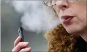  ?? CRAIG MITCHELLDY­ER — THE ASSOCIATED PRESS FILE ?? A woman exhales while vaping from a Juul pen e-cigarette in Vancouver, Wash.