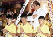  ?? SAKCHAI LALIT — THE ASSOCIATED PRESS ?? Soccer coach Ekkapol Janthawong, center, and members of the rescued soccer team attend a Buddhist ceremony that is believed to extend the lives of its attendees as well as ridding them of dangers and misfortune­s in Mae Sai district, Chiang Rai...