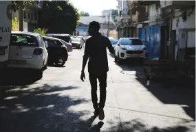  ?? (Amir Cohen/Reuters) ?? TEKLIT MICHAEL, an asylum seeker from Eritrea, is silhouette­d as he walks home in Tel Aviv last year.