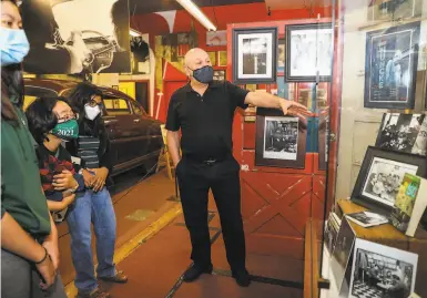  ?? Photos by Yalonda M. James / The Chronicle ?? Beat Museum founder Jerry Cimino leads a tour with recent graduates of San Jose’s Harker School.