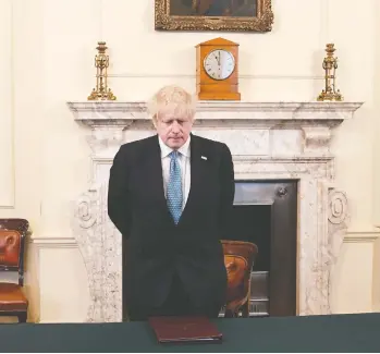  ?? STEFAN ROUSSEAU / POOL/ AFP VIA GETTY IMAGES ?? British Prime Minister Boris Johnson pauses for a minute’s silence in London on Monday to honour National Health Service staff and key workers who have died in the battle against the coronaviru­s.