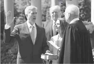  ??  ?? Gorsuch is sworn in as an associate justice of the Supreme Court by Supreme Court Associate Justice Anthony Kennedy (right), as Trump (centre) watches with Louise Gorsuch in the Rose Garden of the White House. — Reuters photo