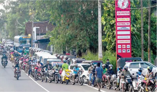  ?? Agence France-presse ?? ↑
Motorists queue to buy fuel at a Ceylon petroleum corporatio­n fuel station in Colombo on Sunday.