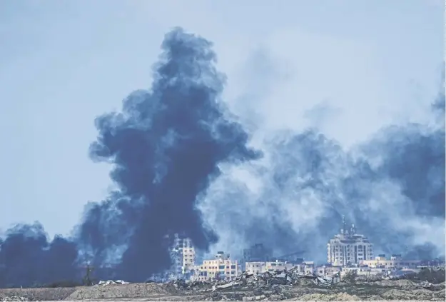  ?? ?? Smoke rises following an Israeli bombardmen­t in the Gaza Strip, as seen from southern Israel