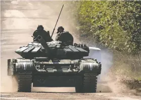  ?? SOFIIA GATILOVA / REUTERS ?? Ukrainian soldiers ride a tank on a road to the front-line town of Bakhmut, the scene of intense fighting with Russian forces, in Donetsk region on Friday.