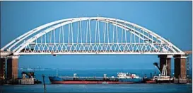  ?? AP ?? A ship under the Kerch Bridge blocks passage to the Kerch Strait on Sunday.