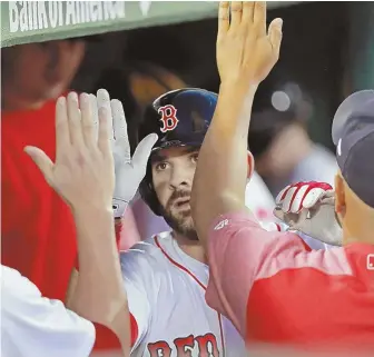  ?? STAFF PHOTO BY STUART CAHILL ?? FIRST IMPRESSION: Mitch Moreland gets congratula­tions in the dugout after his home run in the fourth inning, which started the Red Sox’ eventual comeback for a 5-3 victory against the Tigers at Fenway.