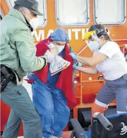  ?? MIGUEL PAQUET / EFE ?? Un guardia civil auxilia a un inmigrante llegado a Motril.