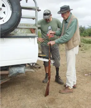  ??  ?? ABOVE RIGHT: Author loading a muzzle-loader while Sakkie looks on with interest.