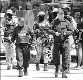  ??  ?? Police Commission­er Gary Griffith on the beat with his officers during an exercise in Beetham Gardens Wednesday. (Photo: Trinidad Guardian)