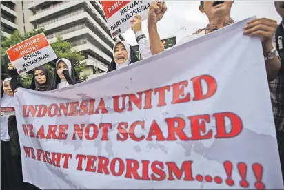  ?? AP PHOTO ?? Activists hold a banner during a rally condemning Thursday’s attack outside the Starbucks cafe where it took place in Jakarta, Indonesia, Friday.