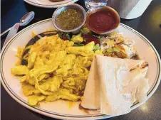  ?? HEATHER HUNTER/FOR THE JOURNAL ?? Breakfast Blue Corn Enchiladas are topped with scrambled eggs and served with a side of hash browns, red and green chile and a flour tortilla at Plaza Café Southside.
