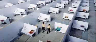  ??  ?? ↑
Security guards walk along a temporary isolation facility in Lahore on Thursday.
Agence France-presse