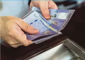  ?? BLOOMBERG PIC ?? The ringgit closed higher against the dollar yesterday, in line with other emerging market currencies, and supported by strengthen­ing crude oil prices.