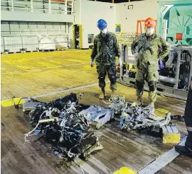  ??  ?? Canadian Armed Forces members and Hercules personnel inspect recovered parts of the helicopter Stalker 22.