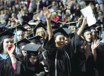  ?? Photos by Ernest A. Brown/The Call ?? Above, Jacqueline Allard, left, and Leeshonel Ayala applaud with other members of the Class of 2017 during Rhode Island College’s Spring Commenceme­nt at the Dunkin' Donuts Center in Providence Saturday morning. Below right, Cedar Hayes takes a second...