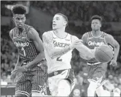  ?? Gary Coronado Los Angeles Times ?? LONZO BALL drives to the basket while being guarded by Orlando’s Jonathan Isaac.