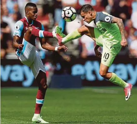  ?? REUTERS PIC ?? West Ham United’s Edimilson Fernandes (left) and Liverpool’s Philippe Coutinho battle for the ball at the London Stadium on Sunday. Liverpool won 4-0.