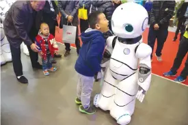  ??  ?? BEIJING: In this Friday, Oct 21, 2016 photo, a Chinese boy shouts into the Canbot, a companion robot, displayed during the World Robot Conference. — AP photos