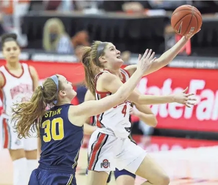  ?? PHOTOS BY ADAM CAIRNS/COLUMBUS DISPATCH ?? Ohio State guard Jacy Sheldon (4) drives to the basket in the first quarter past Michigan’s Elise Stuck. Sheldon’s 3-point basket in the final minute gave the Buckeyes the lead for good.