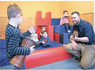  ??  ?? Fabian Salin, Erzieher im Dortmunder Kindergart­en Rumpelwich­te, spielt mit Kindern zur musikalisc­hen Früherzieh­ung auf der Gitarre.