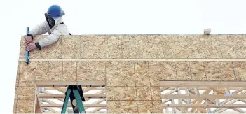  ?? POSTMEDIA FILE ?? A constructi­on worker frames a new house in Regina in this file photo.