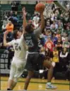  ?? BARRY BOOHER — THE NEWS-HERALD ?? South’s Norman Hughes shoots as Lake Catholic’s Jack LeJeune defends Dec. 5 at Lake Catholic. Lake won, 76-54.