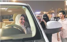  ??  ?? A Saudi woman films and shows support to Samar Al-Moqren who drives through the streets of Riyadh for the first time just after midnight when the law allowing women to drive took effect. — AFP photo