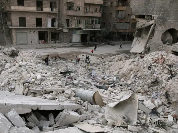  ??  ?? People walk on the rubble of damaged buildings in the rebel held area of al-Kalaseh in Aleppo yesterday (Reuters)