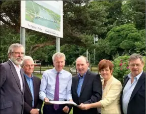  ??  ?? Stormont Finance Minister Mairtín O Muilleoir (centre) looks at plans for the Narrow Water Bridge at the proposed site in Warrenpoin­t last week. He was joined by Gerry Adams (far left) and Cllr. Jim Loughran (far right).