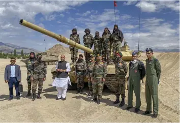  ?? — PTI ?? Defence minister Rajnath Singh poses for a group photo with troops who took part in para dropping and other military exercises at Stakna in Ladakh on Friday. Chief of Defence Services Gen. Bipin Rawat and Army Chief General M.M. Naravane (2nd right) are also seen.